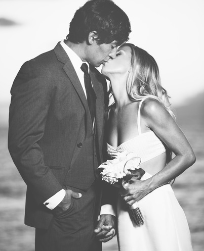 חתן וכלה מתנשקים על החוף